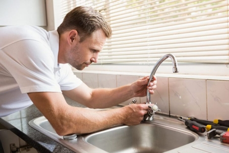 Why You Need A Home Plumbing Inspection - plumber inspecting the kitchen faucet